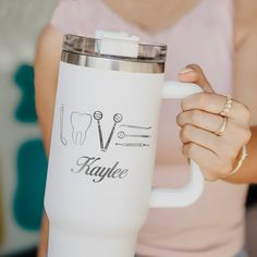 a woman holding a white coffee cup in her hand