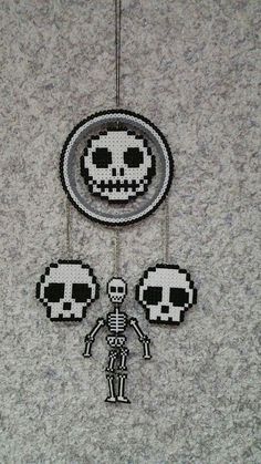 two beaded skeleton ornaments hanging on a wall