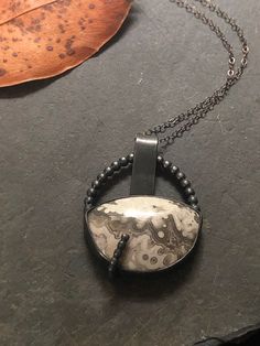 This beautiful Crazy Lace Agate (27x19mm) looks cool and modern in its black oxidized Sterling Silver setting. The black oxidation creates a nice contrast to the stone and adds a cool vibe. The beaded wire is echoing the pattern of the Crazy Lace Agate for a coherent design and adds a whimsical and fun design element. The bail is loosely added and can move a bit on the chain. The pendant is 1 1/4 x 1 inches. Black Agate Wire Wrapped Jewelry, Artisan Black Necklace With Oxidized Finish, Oval Oxidized Metal Jewelry, Unique Black Agate Jewelry, Artisan Hand Forged Black Jewelry, Black Oval Agate Jewelry, Artisan Black Soldered Jewelry, Bohemian Silver Jewelry With Hematite, Artisan Black Soldered Necklace