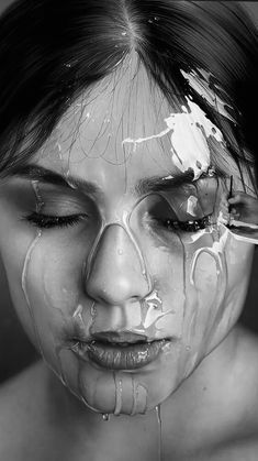 a woman with white paint on her face and hands in front of her face is dripping water