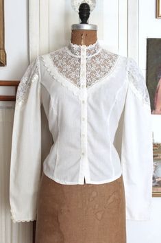 Lovely vintage 1970s Victorian Revival blouse by Gunne Sax (from the Jessica's Gunnies line). Made of a soft and lightweight white cotton (possibly a cotton blend but feels like cotton) with lace trim. This Victorian style blouse features a high lace collar, sheer lace bib with tatted lace trim, functional buttons down the from, long sleeves with sheer lace insets at the shoulders and button cuffs, and princess seams down the front. ☾ Info ☽ Material: feels like cotton, likely a cotton - poly blend (fabric label is missing) Label: Gunnie's by Jessica (Gunne Sax) Condition: excellent vintage condition Freshly laundered and ready to wear! ☾ Measurements ☽ Fits like: small Bust: 34" (no stretch) Waist: 31" (meant to be tucked in, your waist should be much smaller) Length (from shoulder seam): 70s Victorian, White Cotton Shirt, Shirt With Lace, Victorian Revival, Fabric Labels, Gunne Sax, Princess Seams, Style Blouse, Lace Inset