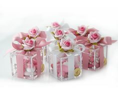 three clear boxes with pink roses in them