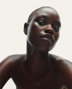 a woman with dark skin is posing for the camera