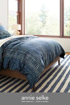 an image of a bedroom setting with blue and white bedding