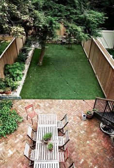 an overhead view of a small backyard with lawn and patio furniture, including table and chairs