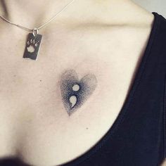 a woman's chest with an abstract tattoo design on her left shoulder and two hearts in the middle