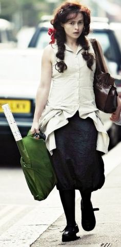 a woman is walking down the street carrying bags