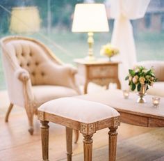 a living room with two chairs and a table in front of a large glass window