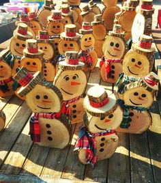 a group of wooden snowmen with hats and scarves