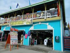 the outside of a blue building with signs and flags hanging from it's balconies