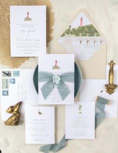 the wedding stationery is laid out on top of each other, including an envelope with a bow