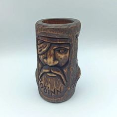 a wooden mug with a carved face on it