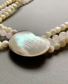 This vintage necklace is so beautiful and is made with the highest quality quartz and mother of pearl. Two of the strands are light yellow mother of pearl and one strand is rose quartz. The mother of pearl clasp is shaped like a kidney bean and is yellow/white. It is 26" long. Elegant Multi-strand Mother Of Pearl Jewelry, Multi-strand Pearl Necklace With Natural Stones For Gifts, Gift Multi-strand Pearl Necklace With Natural Stones, Elegant Multi-strand Mother Of Pearl Necklaces, Elegant Multi-strand Mother Of Pearl Necklace, Mother Of Pearl Multi-strand Jewelry Gift, Elegant Mother Of Pearl Necklace With Gemstone Beads, Elegant Jewelry With Natural Stones And Shell Shape, Elegant Shell Jewelry With Natural Stones