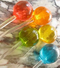 four lollipops sitting on top of a marble table