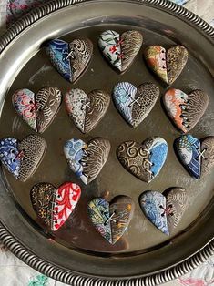 there are many heart shaped cookies in the tray on this tableclothed place mat