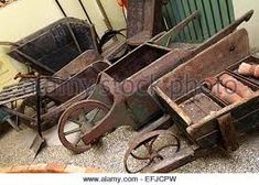 an old rusty cart sitting on the ground next to other junk and items that have been placed around it