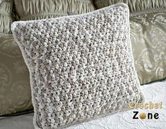 a crocheted pillow sitting on top of a bed