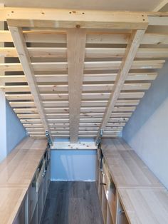 the inside of a small room with wood flooring and wooden slats on the ceiling