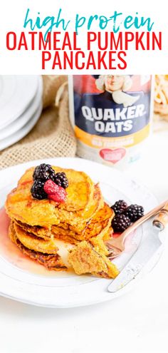 a stack of oatmeal pumpkin pancakes on a plate with berries and syrup