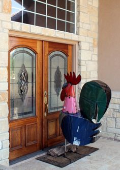 the rooster is standing in front of the door with his head stuck into the trash can