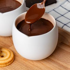 two white bowls filled with chocolate sauce and crackers