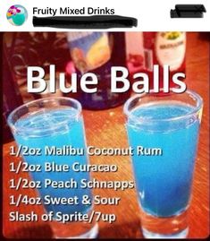 two blue balls are sitting next to each other on a table with drinks in the background