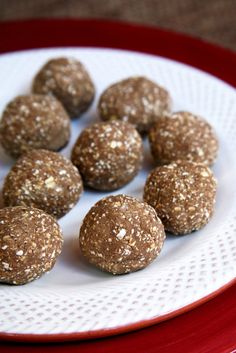 several chocolate balls on a white plate with red trim