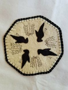 a white cloth with black birds in the center and on it's sides is a woven tray