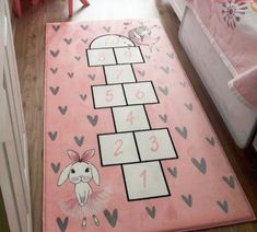 a child's bedroom with a pink rug that has numbers and animals on it