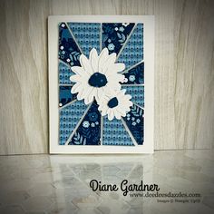 a blue and white card with some flowers on the front, and one flower in the middle