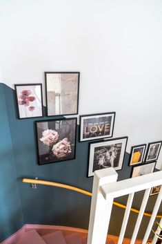 a staircase with pictures on the wall next to it and a hand rail in front