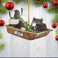 an ornament hanging from a christmas tree with items in the boat on it