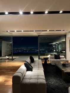 a living room filled with furniture and large windows