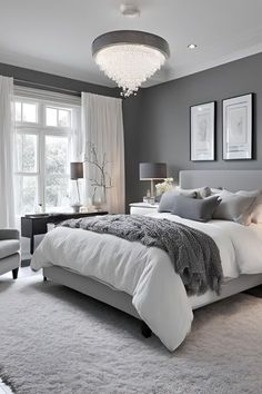 a bedroom with gray walls and white bedding in the center is decorated with silver accents