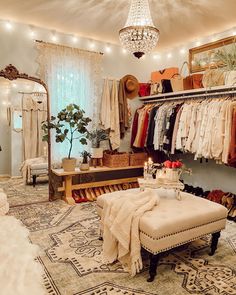 a room with clothes hanging on the wall and a bench in front of it that has a chandelier