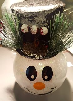 a snowman with a top hat and pine branches