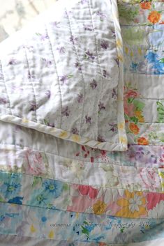 an unmade bed with colorful flowers on it