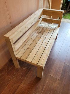 a wooden bench sitting on top of a hard wood floor