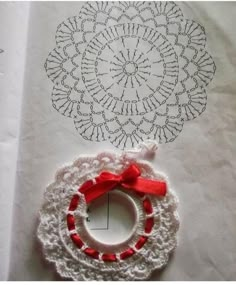 a paper bag with a crochet doily on it and a red ribbon