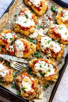 chicken parmesan bites on a baking sheet with a fork and napkin next to them