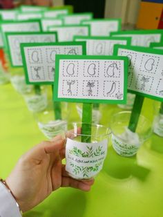 a person holding a cup with some sort of words on it in front of other cups