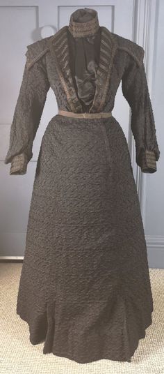 A smart antique mourning dress dating to the very late 1890s / early 1900s - Victorian / Edwardian eras - externally in excellent condition. Two pieces, bodice and skirt, in textured silk, open weave, with an embossed wavy textured finish. The bodice has a sturdy cotton underneath layer, fully boned and fastening at centre front with hooks. Over this at the front a loose, pleated plain silk panel fastens across with hooks, with the tall collar in the same silk, trimmed with decorative braid. Two Fall Historical Victorian Dress, Victorian Dress With Historical Design For Fall, Fall Victorian Dress With Historical Design, Antique Victorian Dress For Formal Occasions, Vintage Victorian Dress For Fall Evening, Formal Vintage Victorian Dress With Buttons, Victorian Skirt, Antique Dresses, Tight Dress Outfit