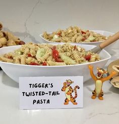 there are two bowls of pasta with winnie the pooh figurines next to them