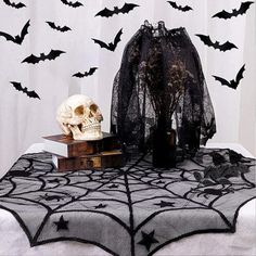 a table topped with a skull and a black netted spider web covered in bats