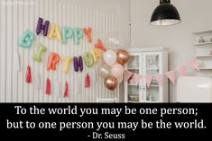 a birthday party with balloons and streamers hanging on the wall, says to the world you may be one person, but to one person you may be the world dr seuss