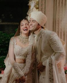 the newly married couple is posing for a photo together in their wedding outfits and turbans