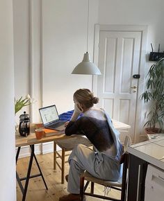 a person sitting at a table with a laptop