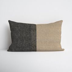 a black and white pillow with two different colors on the front, one brown and one beige