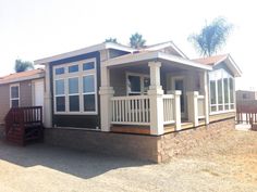 a mobile home sits in the middle of a dirt lot