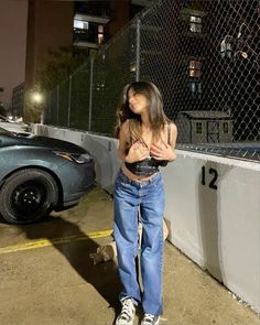 a woman standing in front of a fence at night